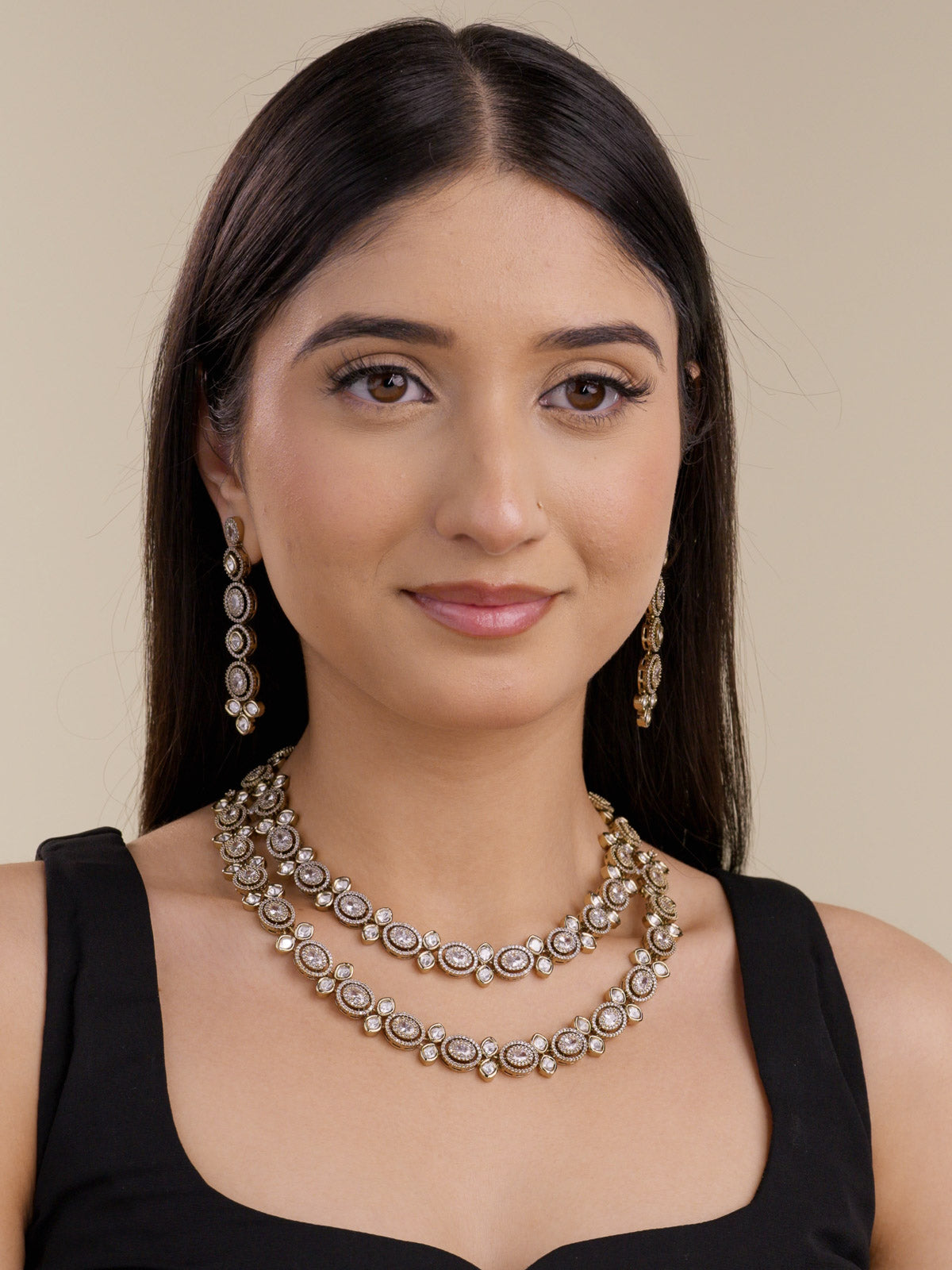 Kundan necklace set with double layered kundan-look stones and American Diamond detailing in antique gold tone, with matching drop earrings, worn on model full look