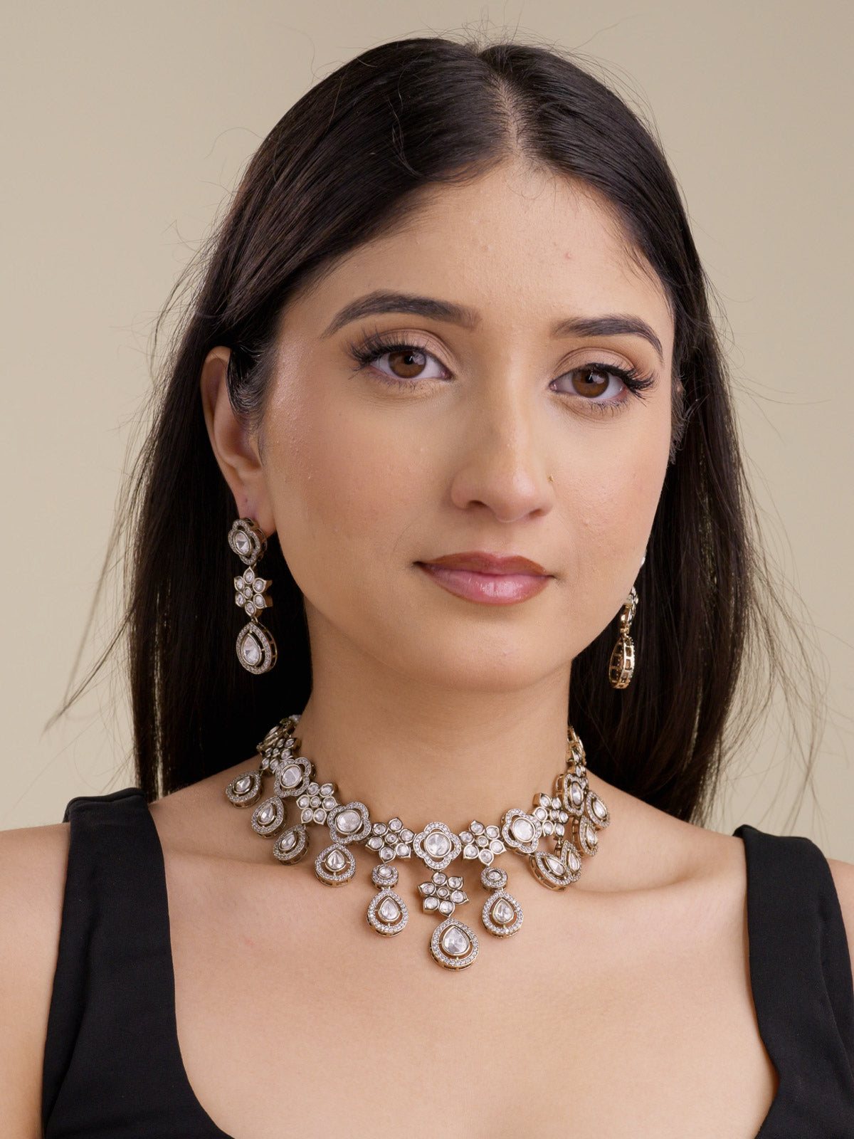 Full Kundan necklace set with matching earrings on model, featuring teardrop kundan-look stones, American Diamond detailing, antique gold tone, and neutral stonework