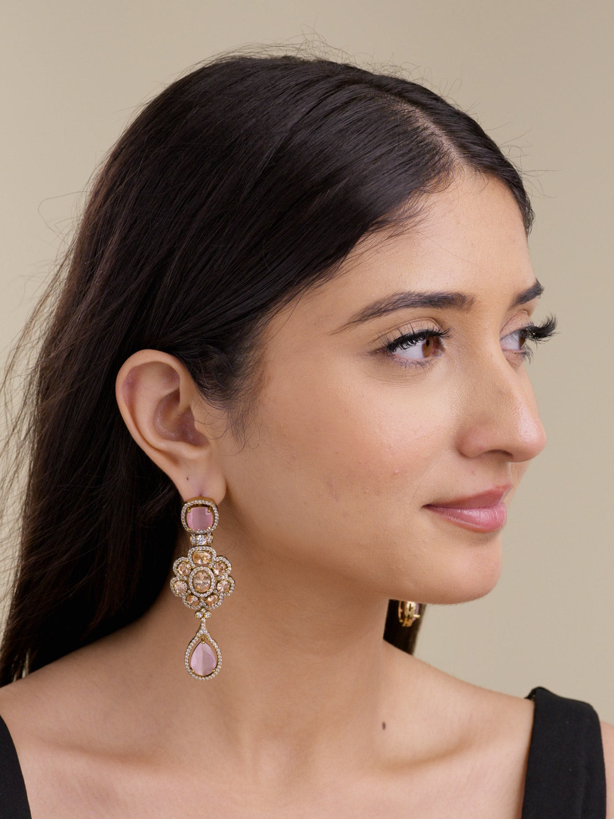 Model wearing antique tone American Diamond earrings with a pink cushion stud, champagne CZ floral centre stones, white CZ detailing, and a pink teardrop drop in a side portrait shot.