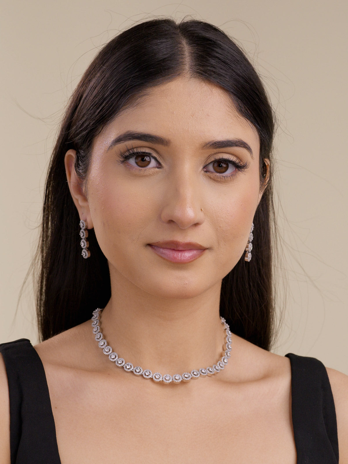 Model wearing american diamond necklace set with matching drop earrings in silver tone featuring fine round halo-style detailing