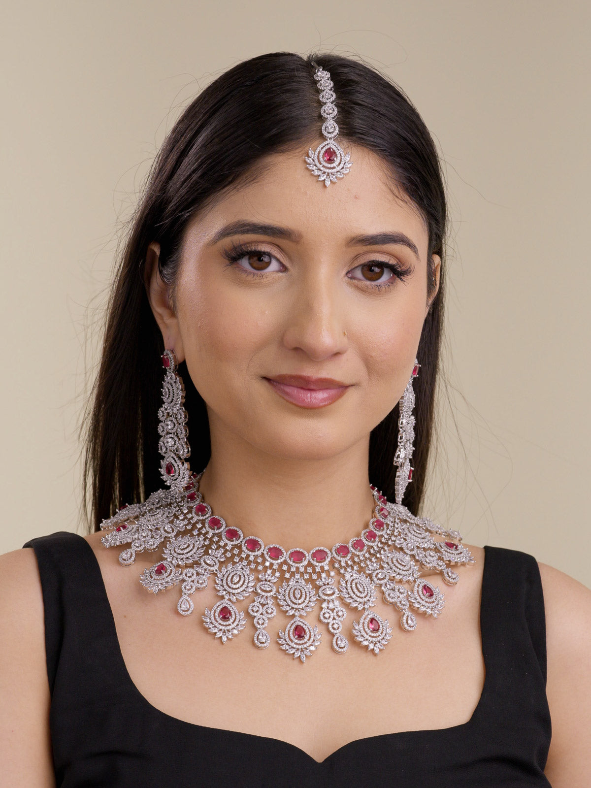 American Diamond necklace set in silver tone with ruby-red stones, shown on a model with matching long earrings and maang tikka in a full front bridal-style view.