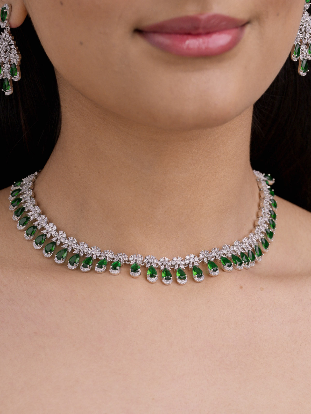American Diamond green variant necklace set in silver tone with clear CZ stones and green teardrop fringe on model close-up