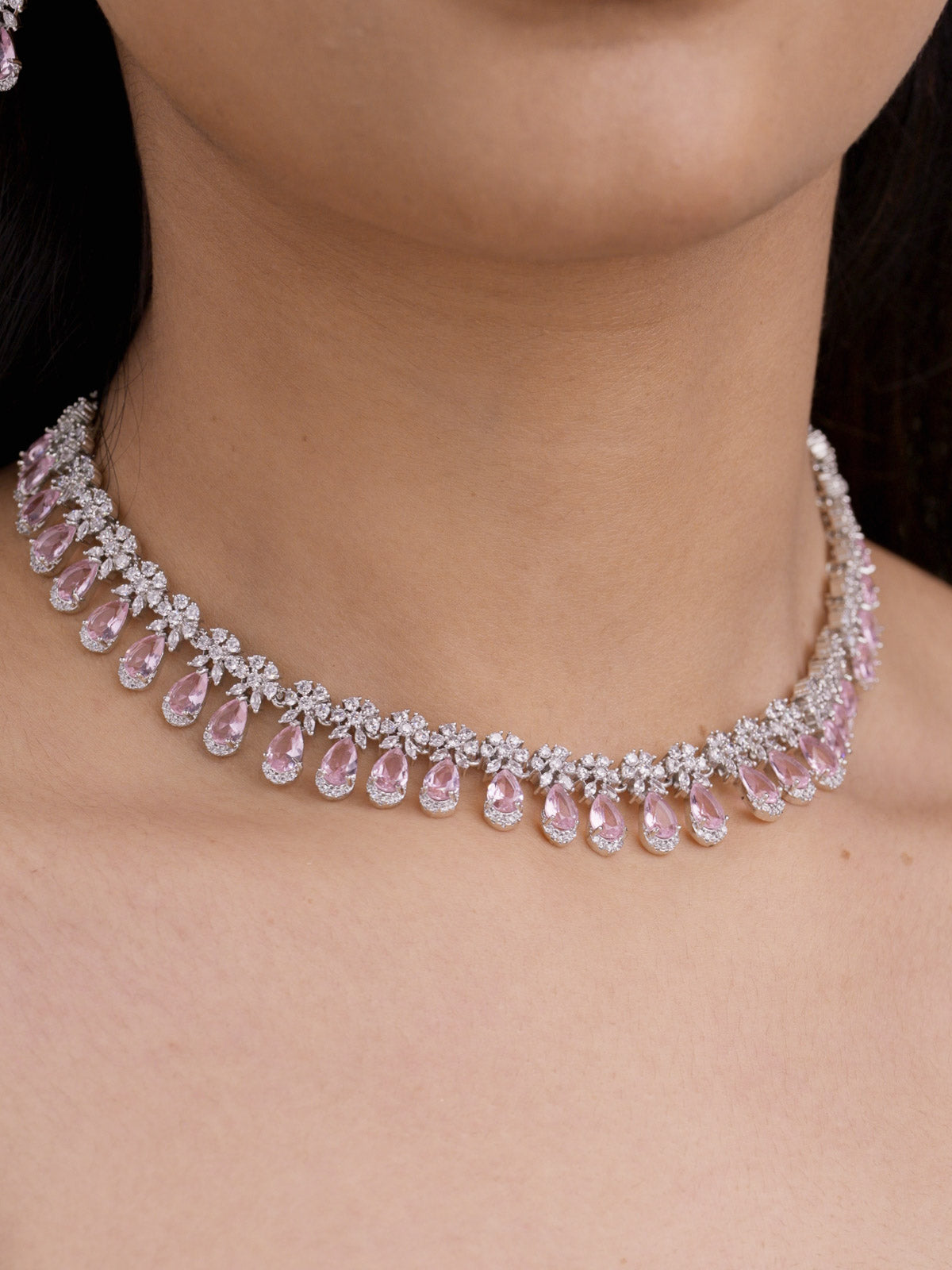 American Diamond pink variant necklace set in silver tone with clear CZ stones and pink teardrop fringe on model close-up