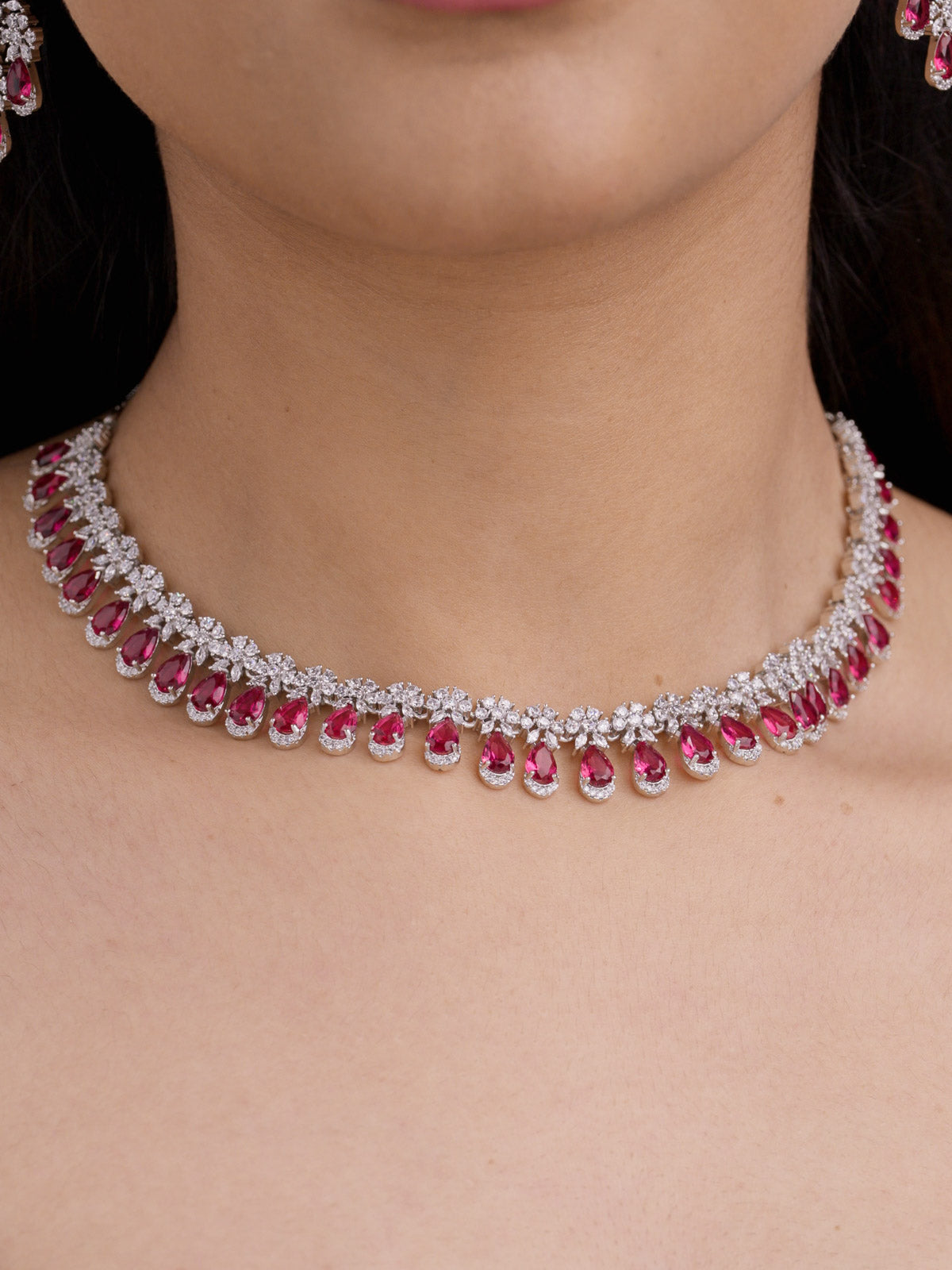 American Diamond ruby red variant necklace set in silver tone with clear CZ stones and ruby red teardrop fringe on model close-up