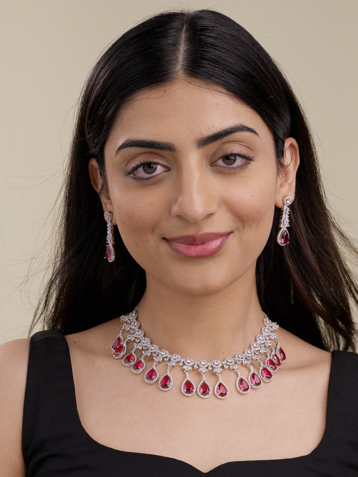 American Diamond necklace set in silver tone with ruby red teardrop fringe, CZ detailing, and matching drop earrings on model front-view image