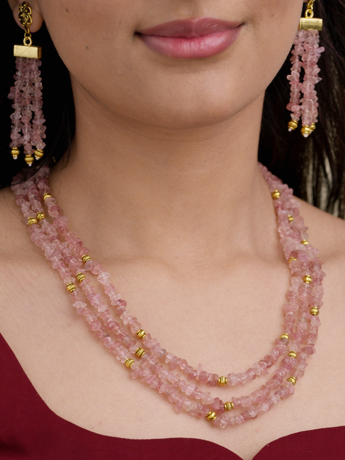 Beadwork necklace set with layered chip-style pink bead strands, gold tone accents, and matching beaded tassel earrings on model close-up