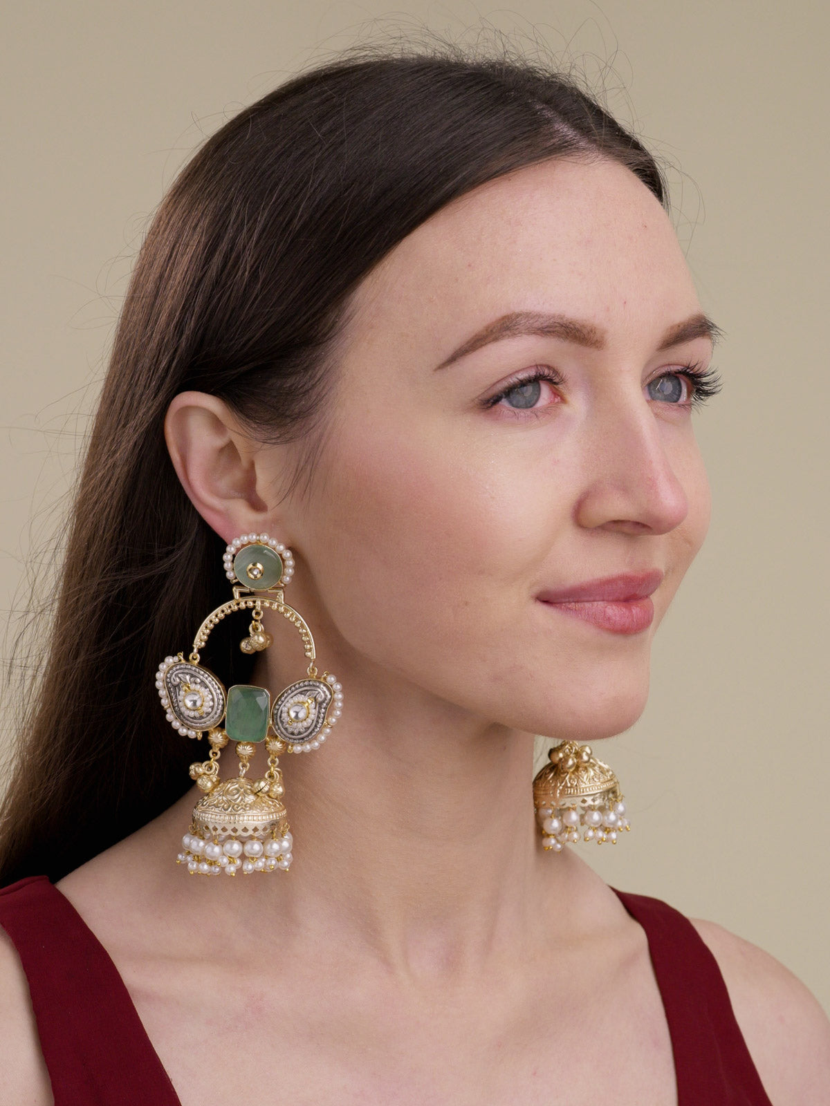 Model wearing fusion jhumka earrings in multi tone with mint stones, silver-tone paisley side panels, pearl borders, ghungroo drops and pearl-fringed jhumka domes