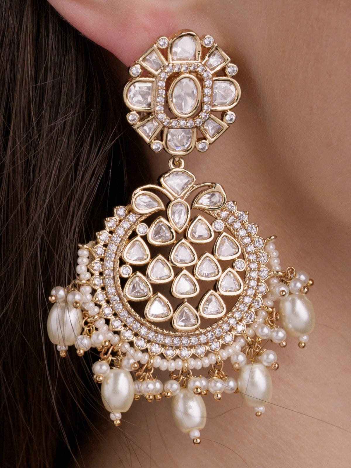 Close-up of a Champagne Gold Tone Kundan earring worn on a model, showing a round floral stud top, teardrop kundan-look stones, American Diamond detailing, and layered pearl fringe drops.