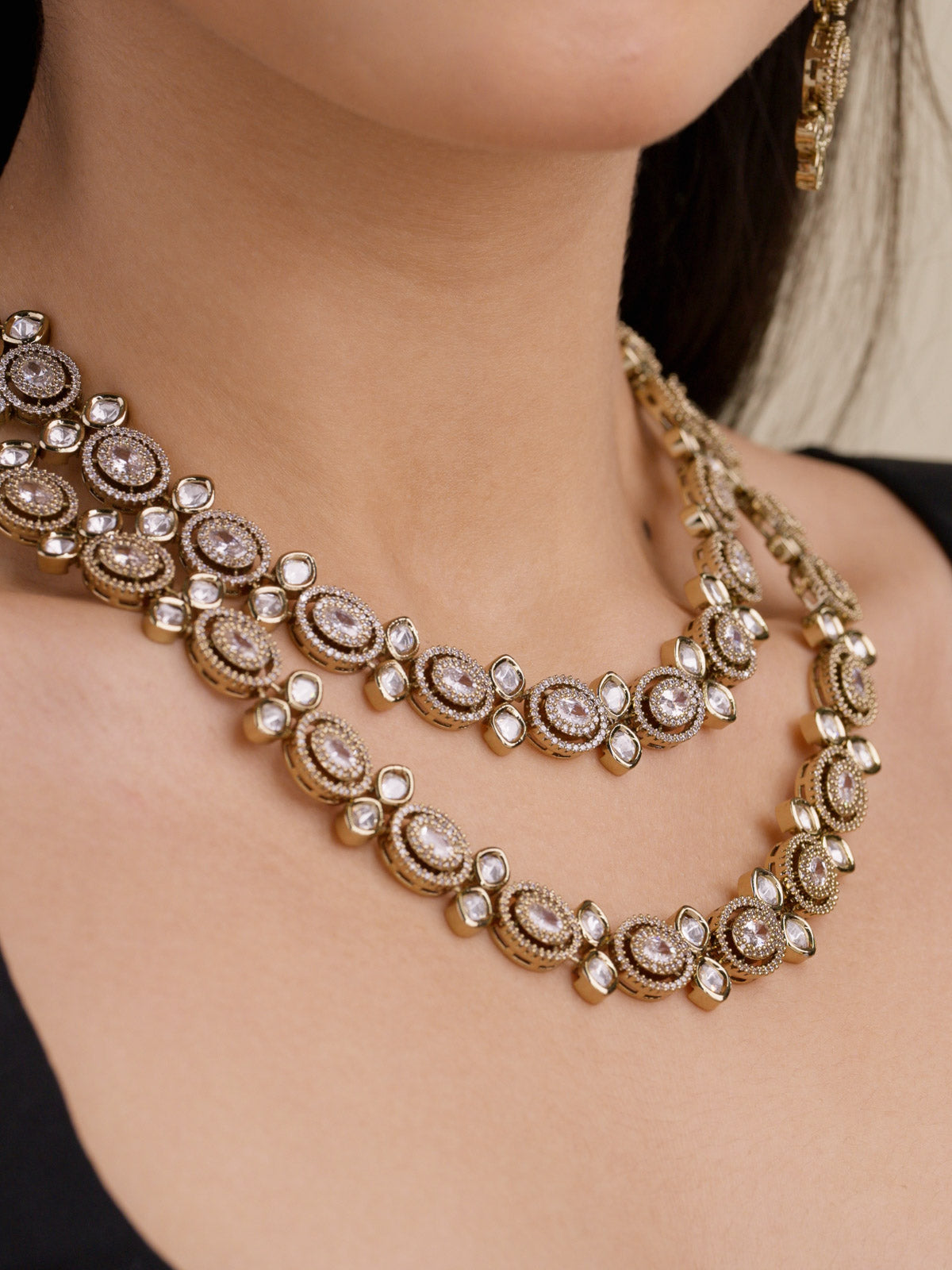 Kundan necklace set with double layered kundan-look stones and American Diamond detailing in antique gold tone, worn on model neckline
