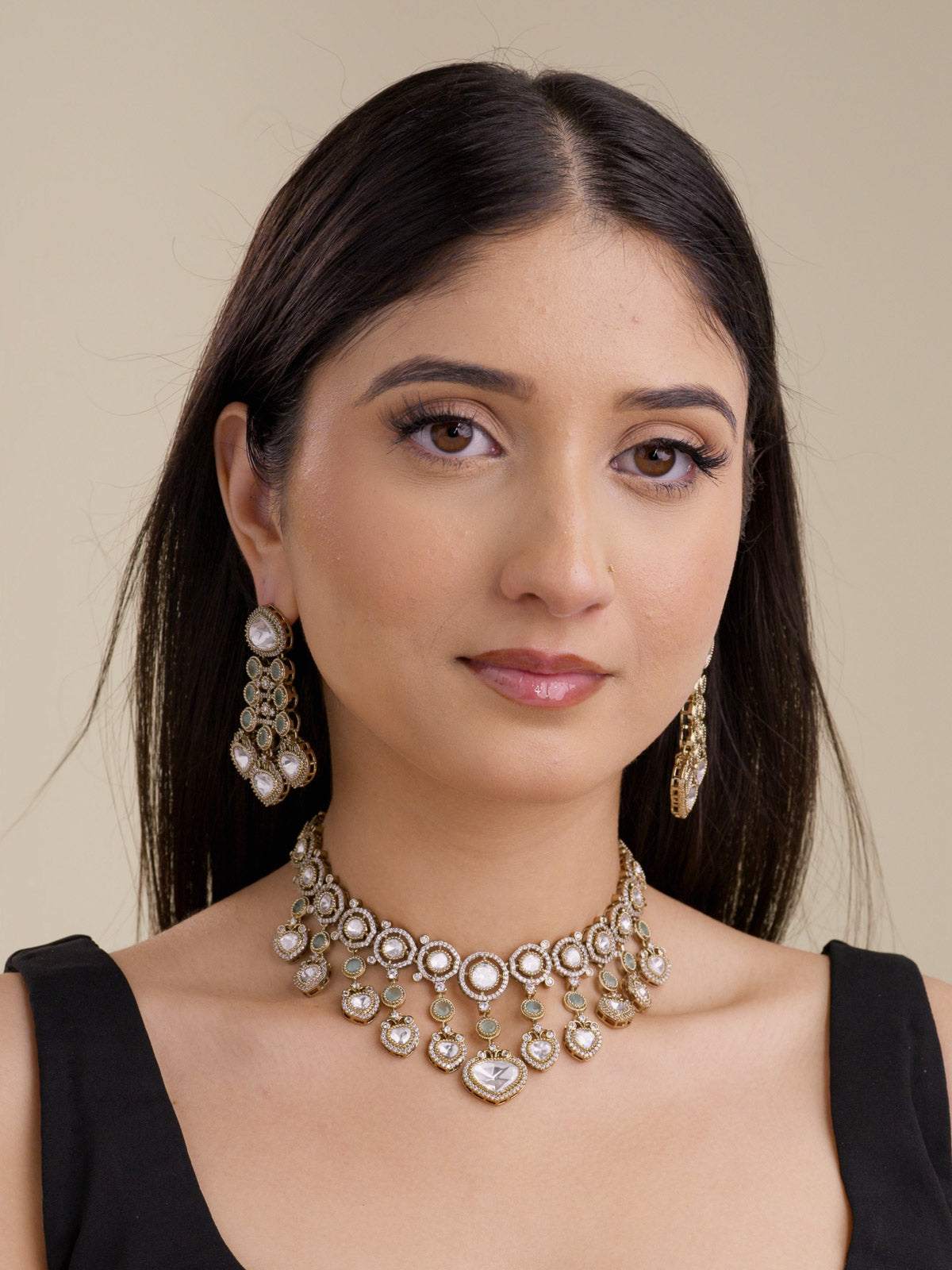 Model wearing an antique gold tone Kundan necklace set with mint accents, kundan-look stones, American Diamond detailing, and matching earrings.