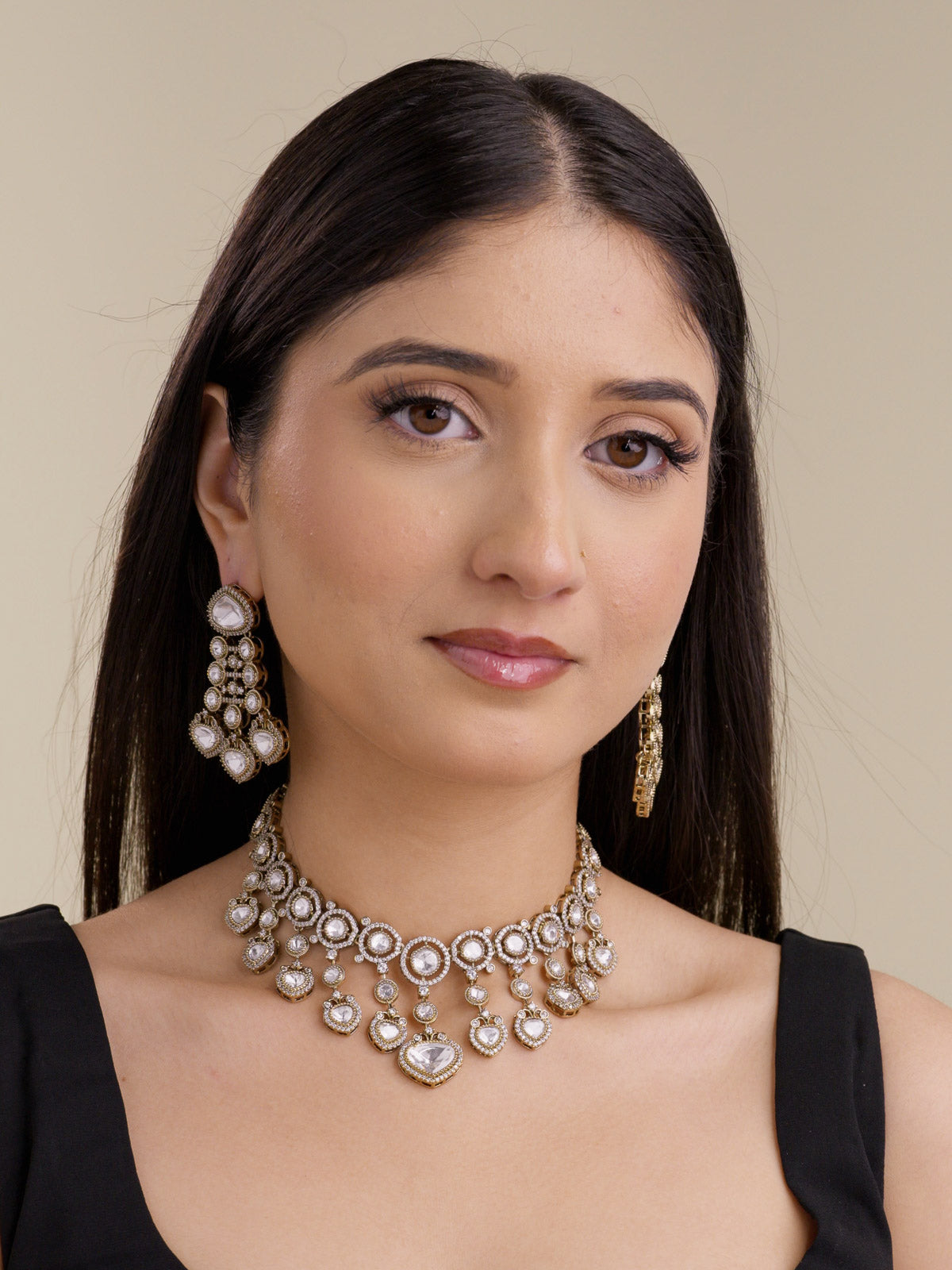 Model wearing an antique gold tone Kundan necklace set with neutral kundan-look stones, American Diamond detailing, and matching earrings.