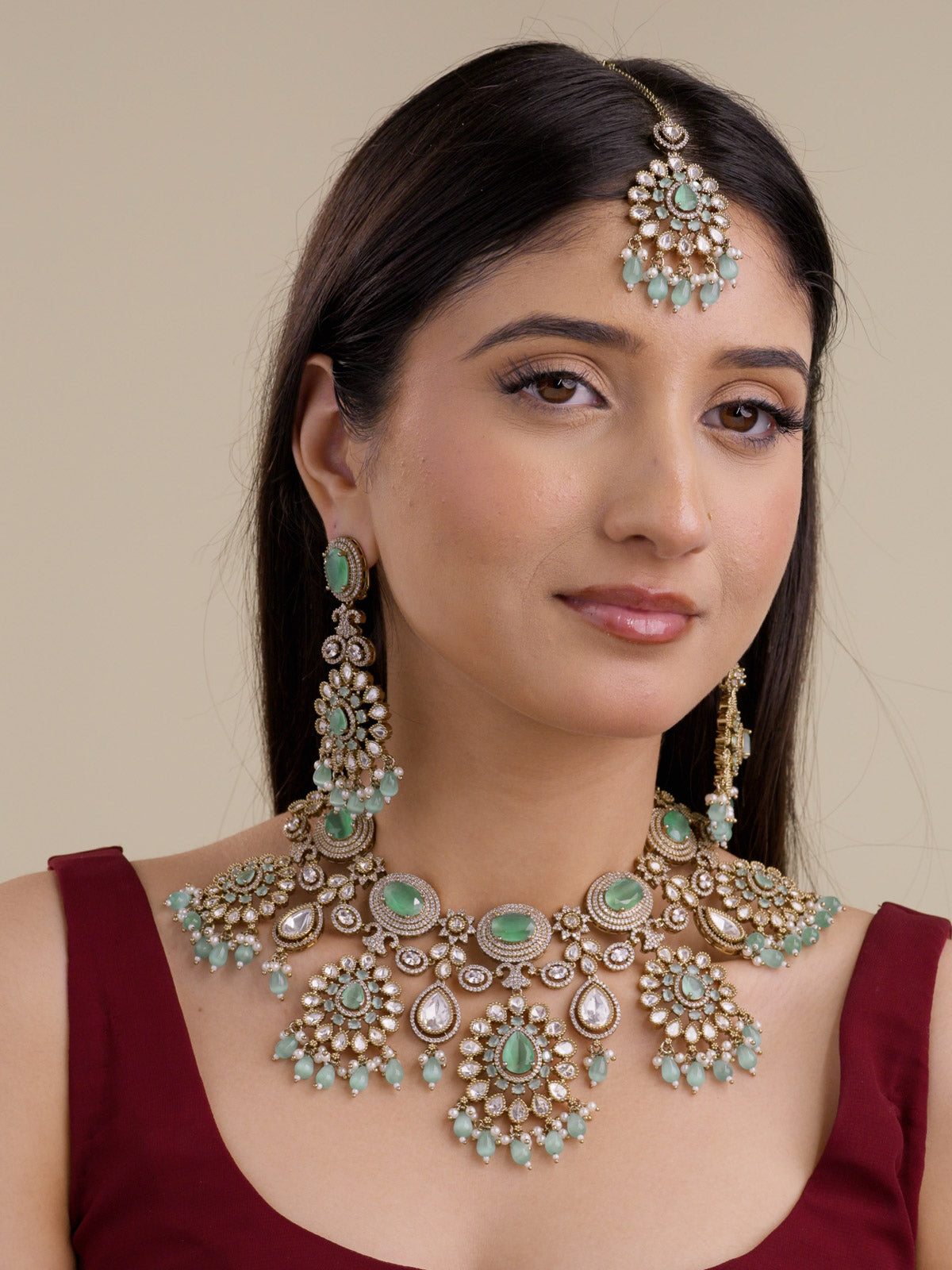 Model wearing mint bridal Kundan necklace set in antique gold tone with matching earrings and maang tikka, showing mint centre stones, teardrop kundan-look stones, American Diamond detailing, and mint bead drops.