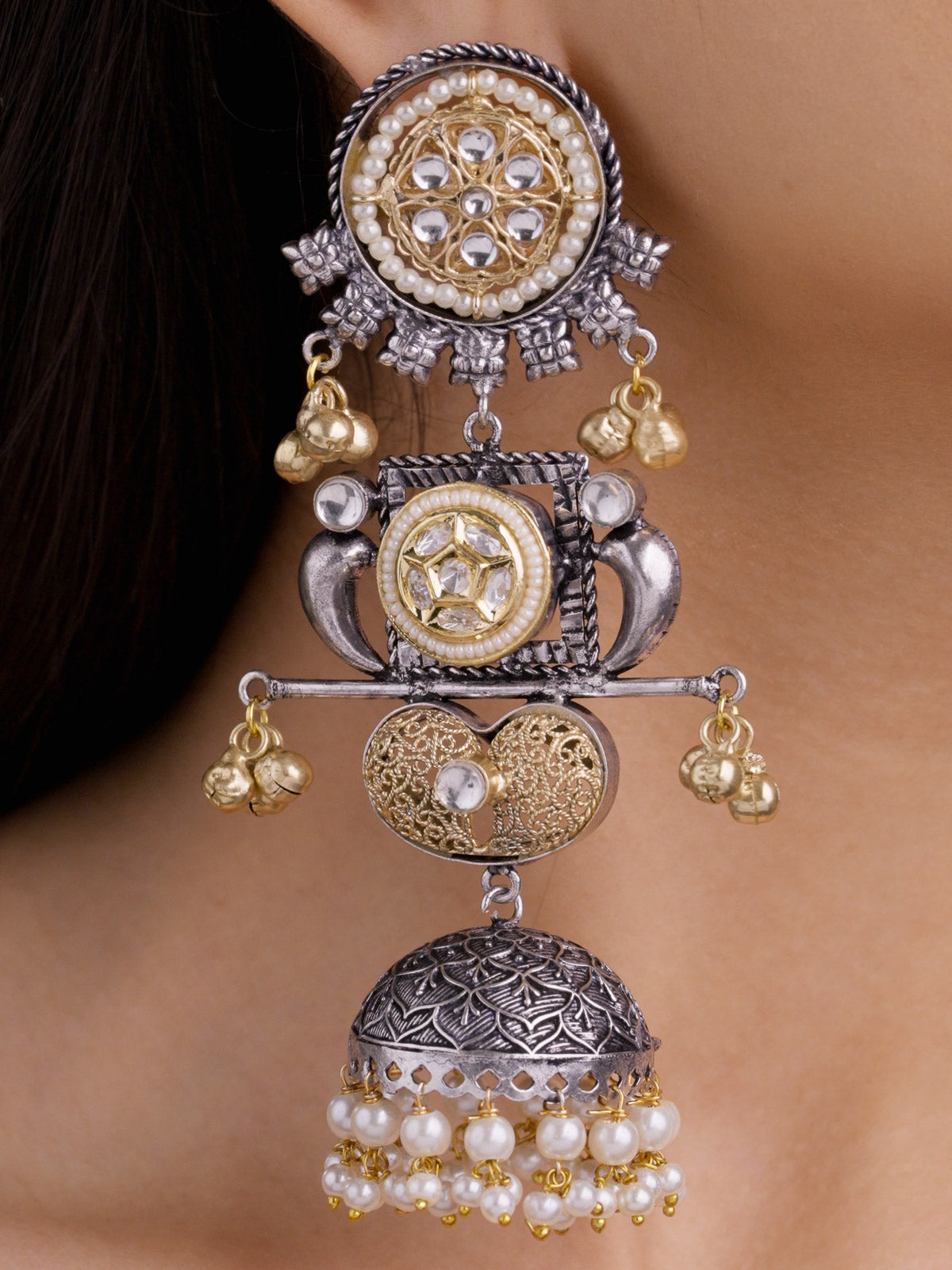 Close-up detail of a statement oxidised multi tone earring with a round kundan-look top, gold-tone bell drops, carved jhumka dome, and pearl-style lower hanging drops.